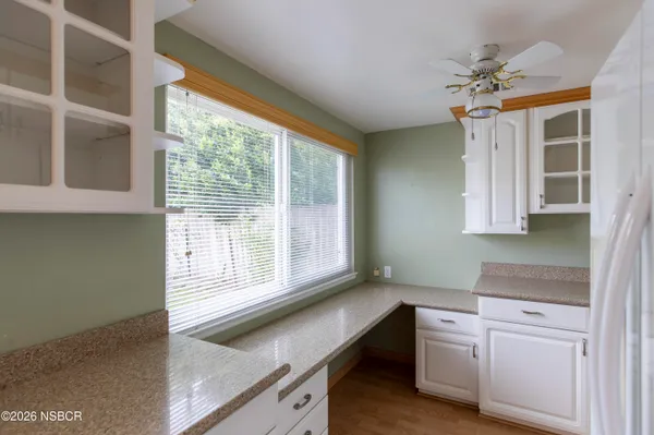 a kitchen with white cabinets and a window