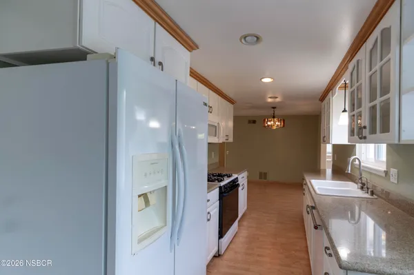 a kitchen with stainless steel appliances granite countertop a refrigerator and a sink
