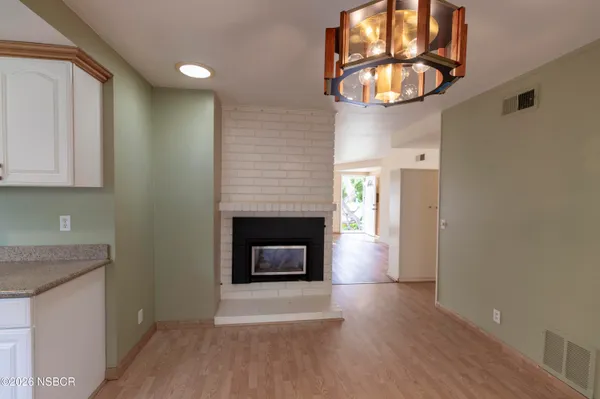 a view of empty room with wooden floor and fireplace