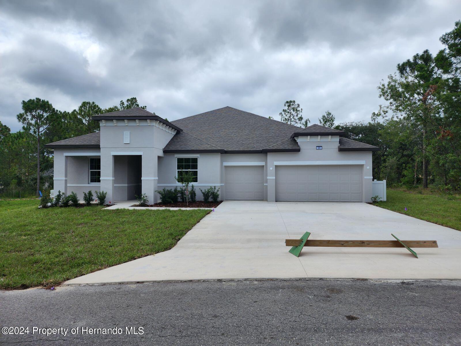 24 Rudbeckia Court Homosassa, FL 34446 - Photo 1 of 1 a front view of a house with a yard and garage