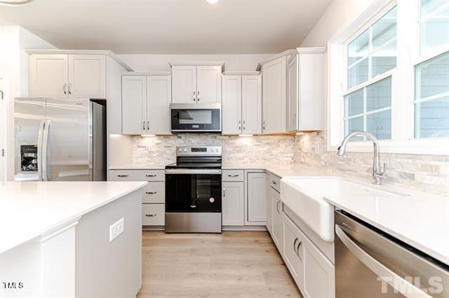 a kitchen with kitchen island granite countertop a sink stainless steel appliances and cabinets