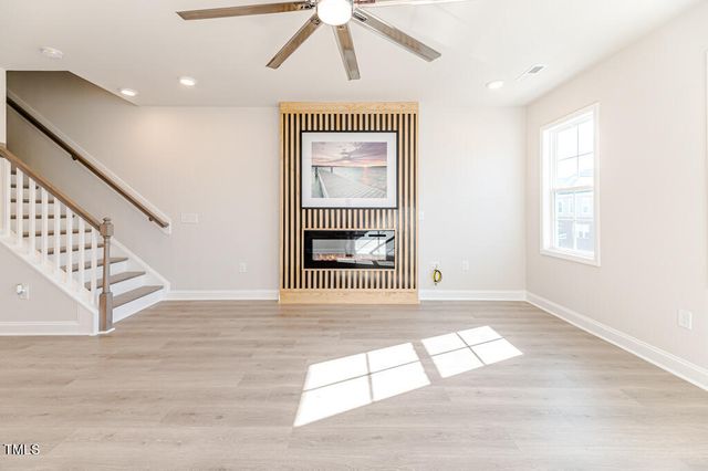 an empty room with windows and fireplace