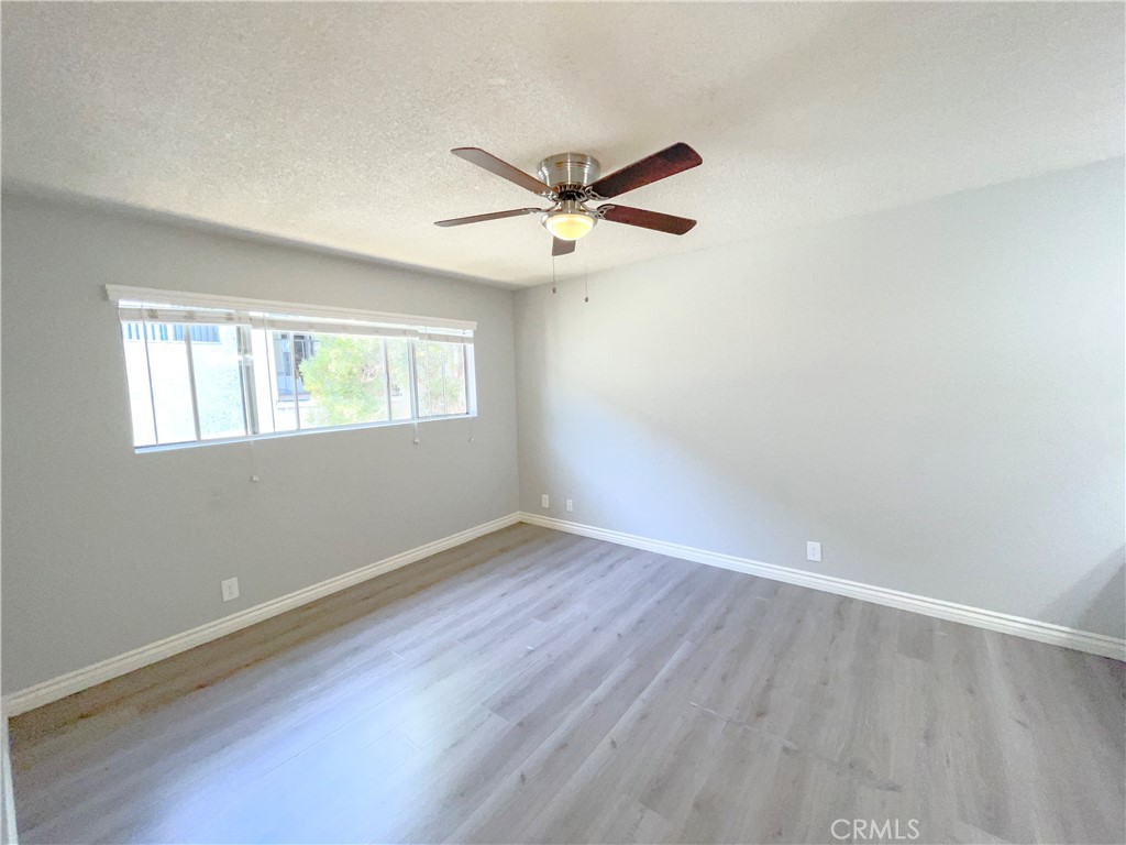 13717 Chadron Avenue, Unit 26 Hawthorne, CA 90250 - Photo 7 of 12 an empty room with wooden floor ceiling fan and windows