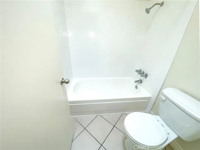 a white toilet sitting next to a bath tub
