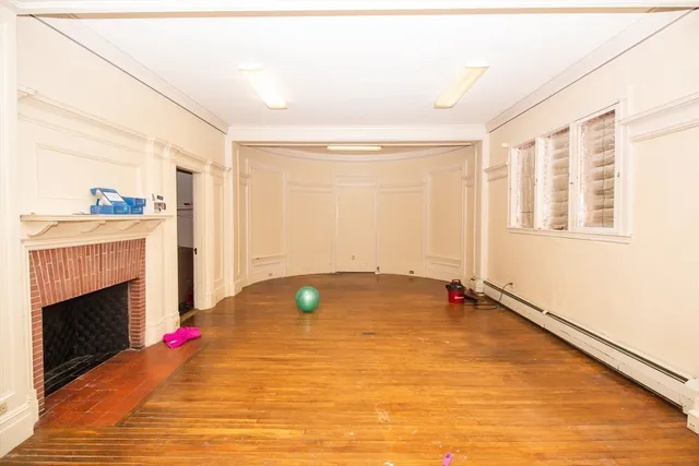 a view of an empty room with a fireplace and a window