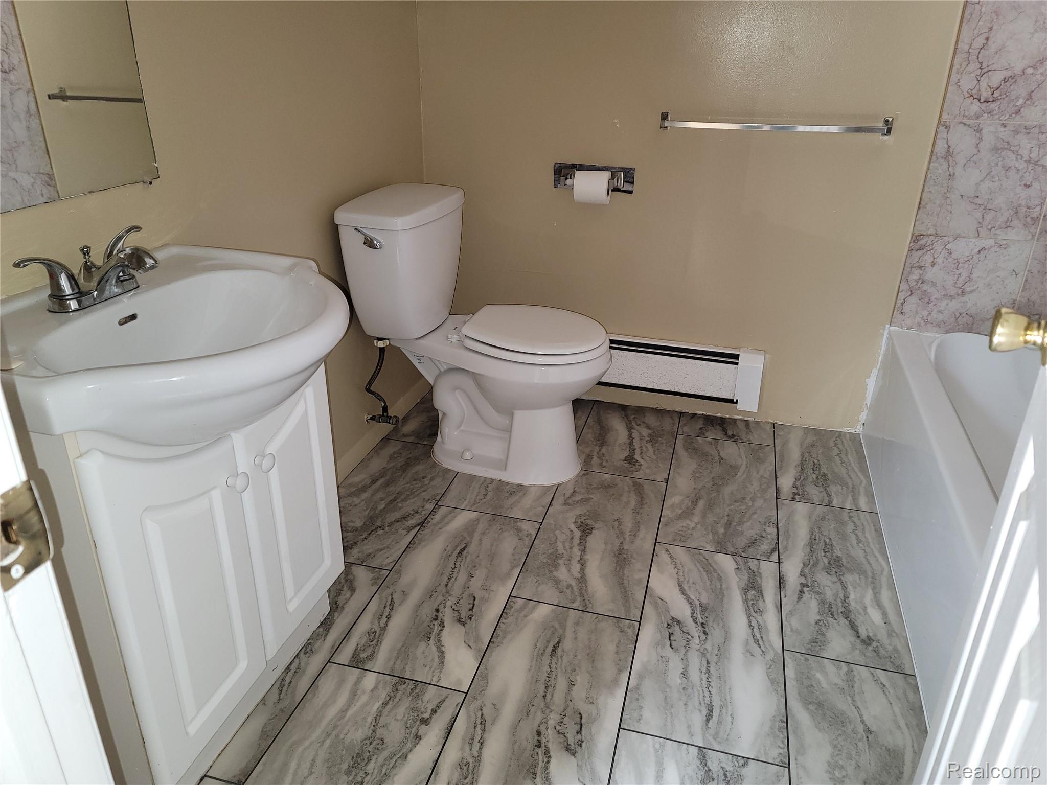 Bathroom featuring vanity, a bathtub, and a baseboard radiator