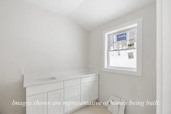a view of a kitchen with white cabinets and wooden floor