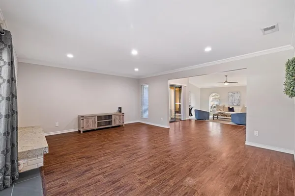 a view of empty room with wooden floor