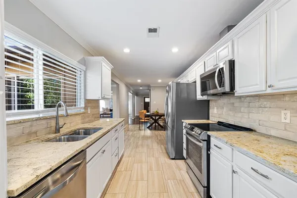 a kitchen with stainless steel appliances granite countertop a sink stove and cabinets