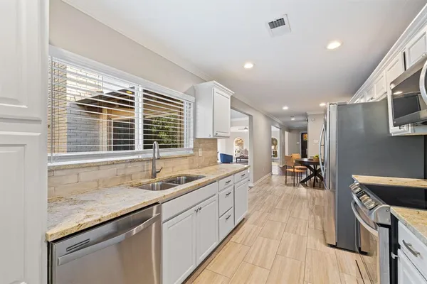 a kitchen with a refrigerator sink and cabinets