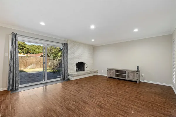 an empty room with windows and ceiling fan