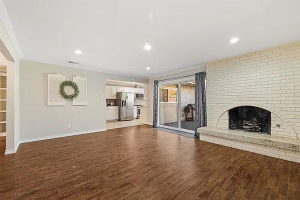 an empty room with wooden floor and fireplace