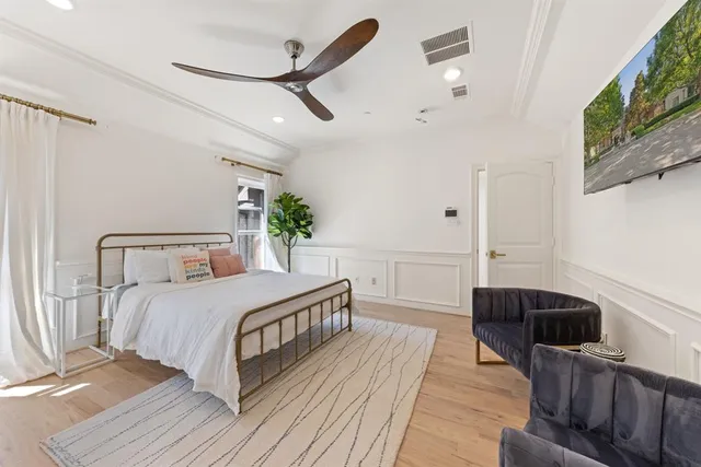 a bedroom with a bed a flat screen tv and a fireplace