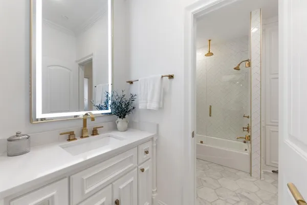 a bathroom with a sink tub vanity and a mirror
