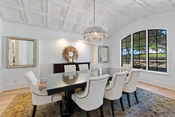 a view of a dining room with furniture a chandelier and wooden floor