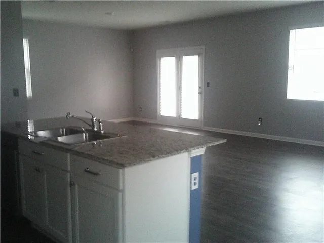 a bathroom with a granite countertop sink and window