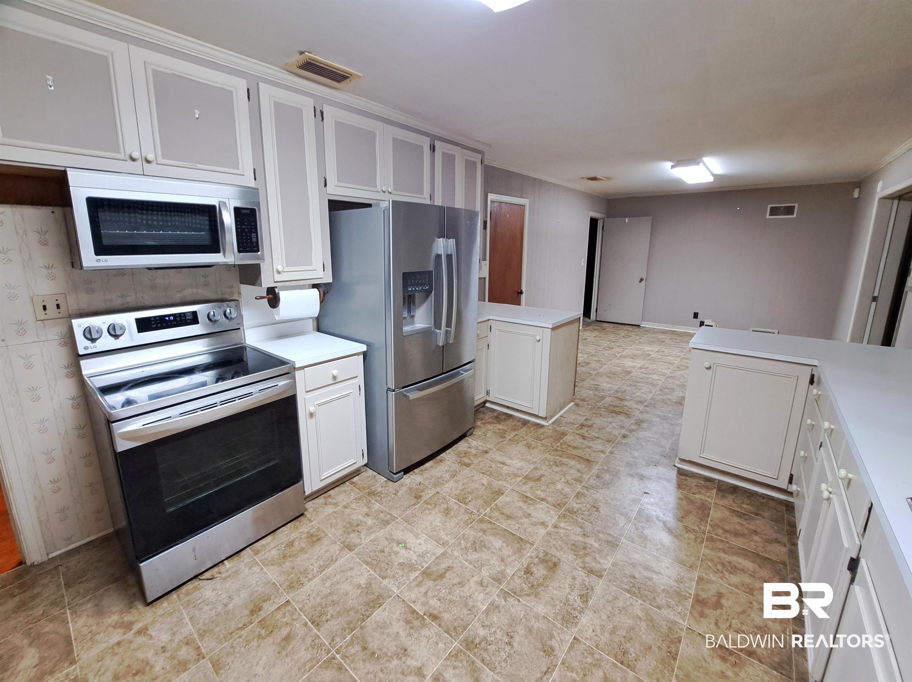 249 Newton Parkway Evergreen, AL 36401 - Photo 6 of 28 Kitchen with stainless steel appliances, white cabinets, a peninsula, and light countertops