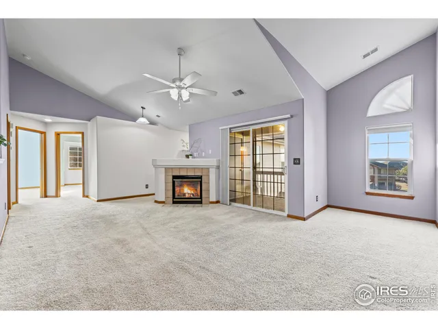 a view of an empty room with a fireplace and a window