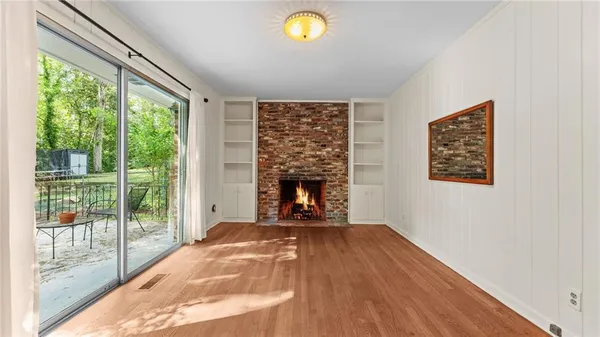 a view of an empty room with a fireplace and a window