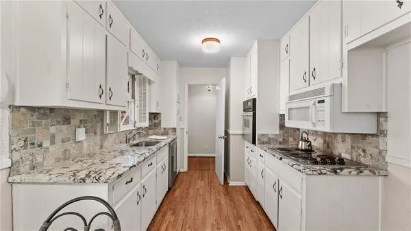 a kitchen with stainless steel appliances granite countertop a stove a sink and a refrigerator