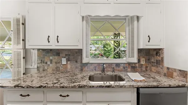 a kitchen with granite countertop a sink and a stove