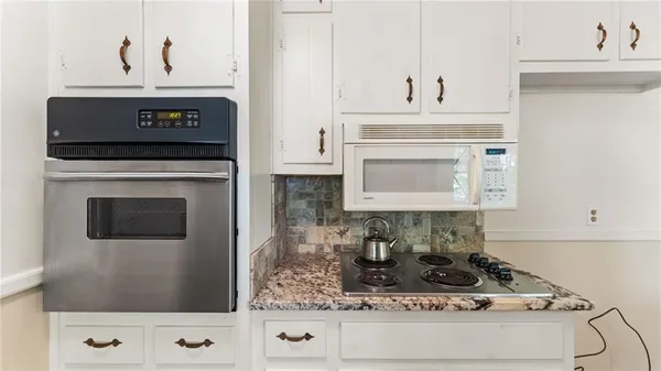 a stove top oven sitting inside of a kitchen
