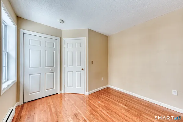 a view of empty room with wooden floor