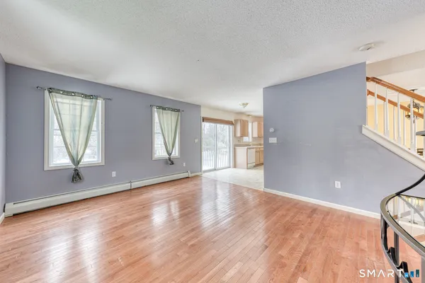 an empty room with wooden floor and windows
