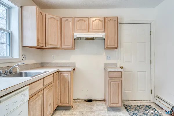 a kitchen with white cabinets and a refrigerator