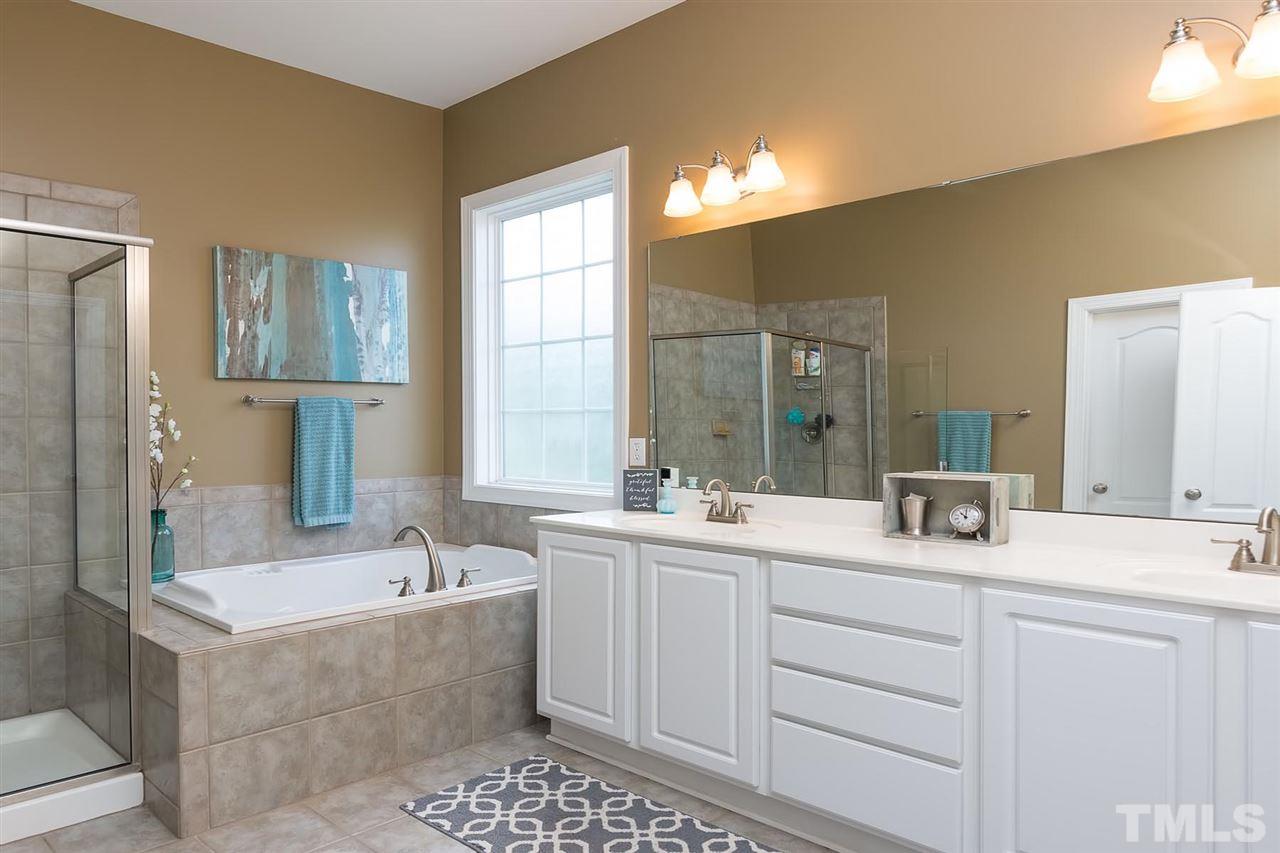 10121 Darling Street Raleigh, NC 27613 - Photo 13 of 25 a bathroom with a tub sink and mirror