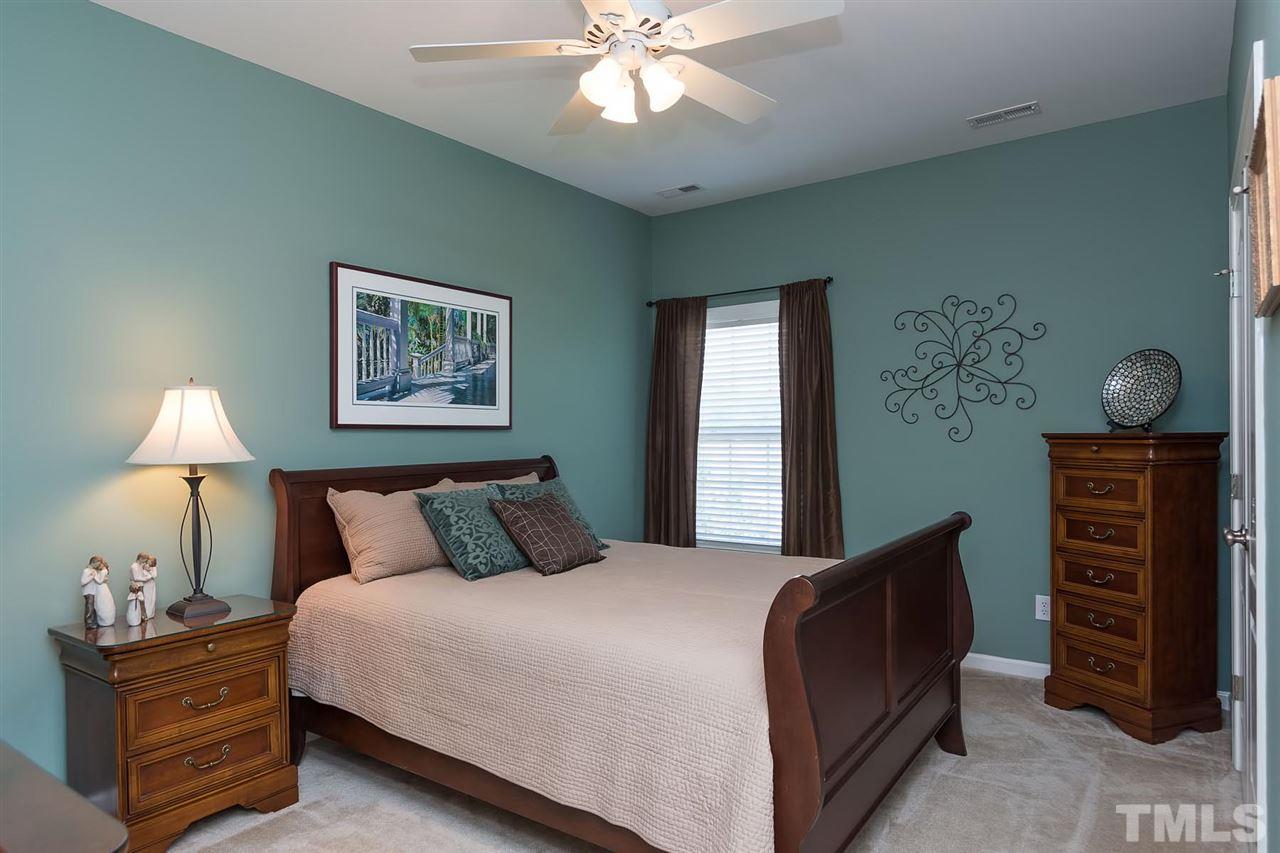 10121 Darling Street Raleigh, NC 27613 - Photo 17 of 25 a bedroom with a bed and a chandelier