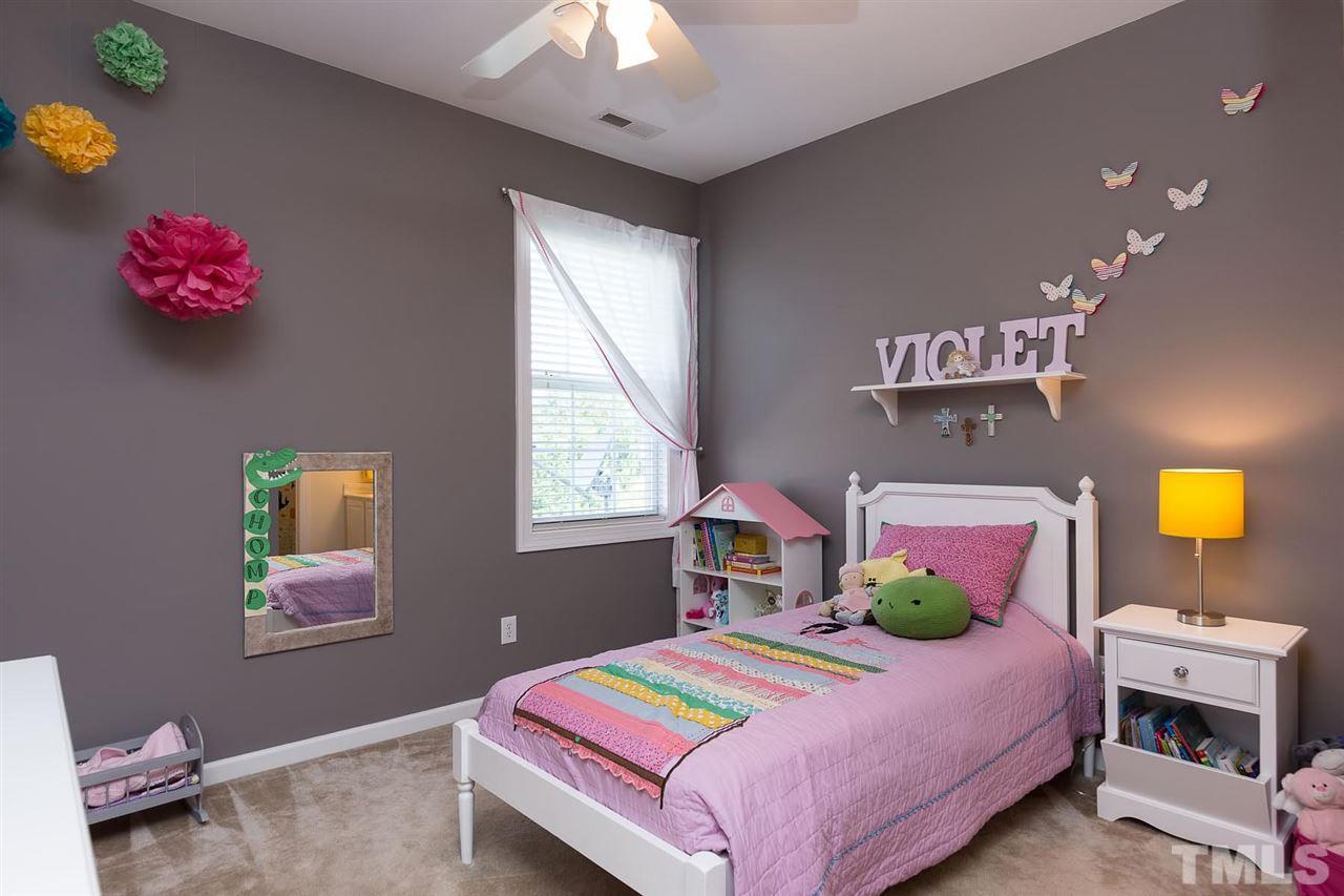 10121 Darling Street Raleigh, NC 27613 - Photo 18 of 25 a bedroom with a bed and a chandelier