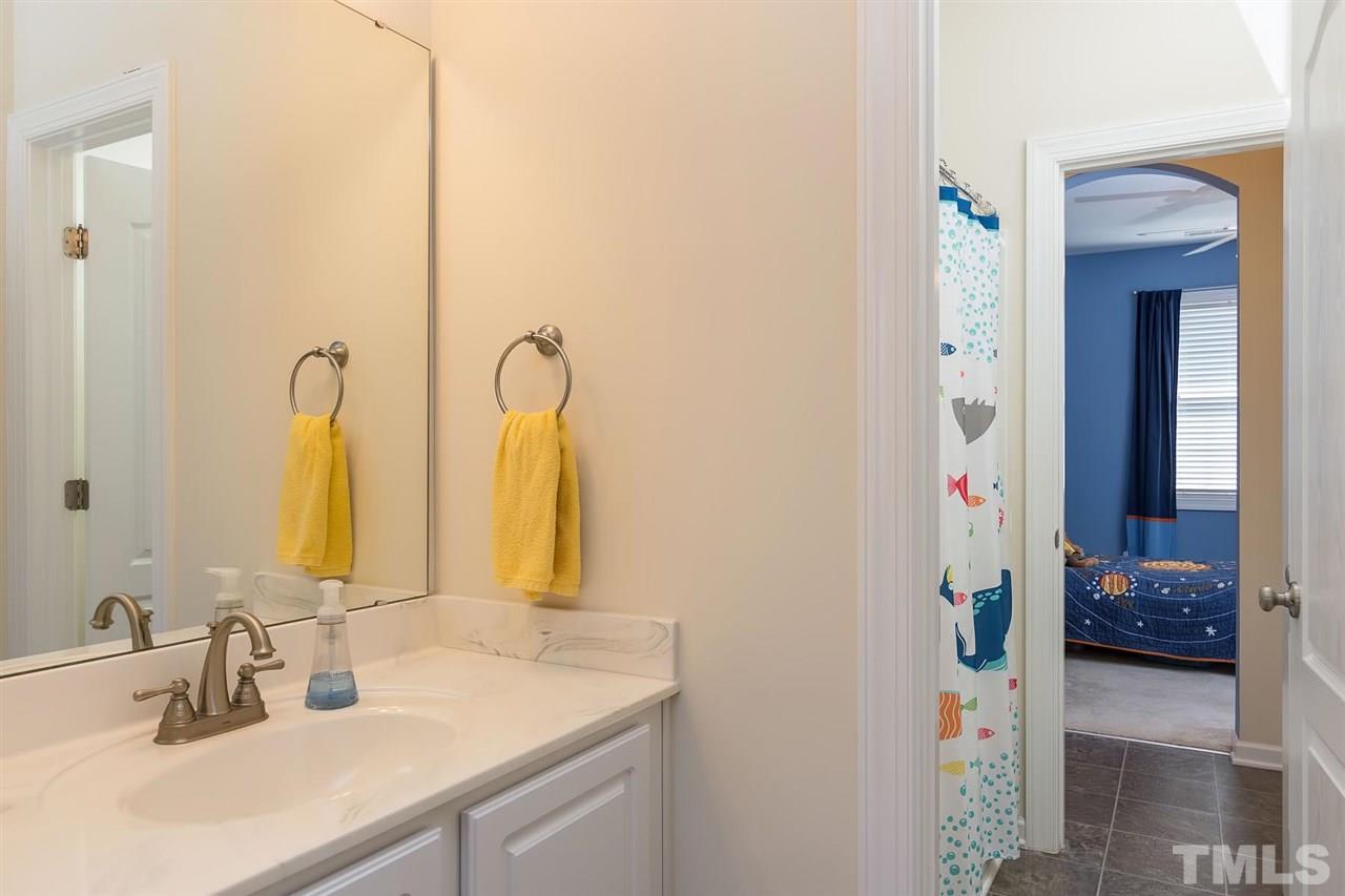 10121 Darling Street Raleigh, NC 27613 - Photo 19 of 25 a en suite bathroom with a sink and a mirror
