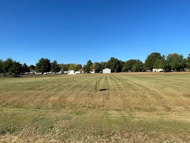 a view of a field with an trees in the background