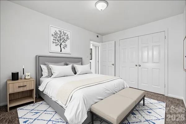 a bedroom with a bed and a lamp on dresser