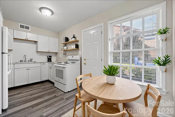 a kitchen with a white table and chairs in it