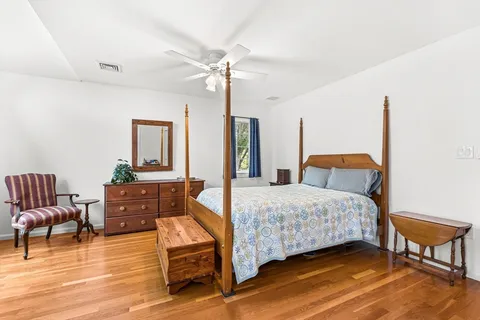 a bedroom with a bed and wooden floor