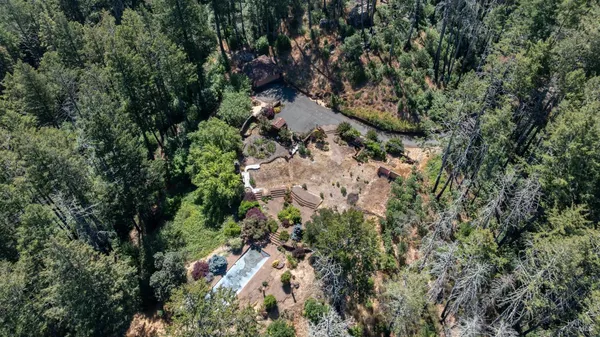 an aerial view of residential house with space and trees all around