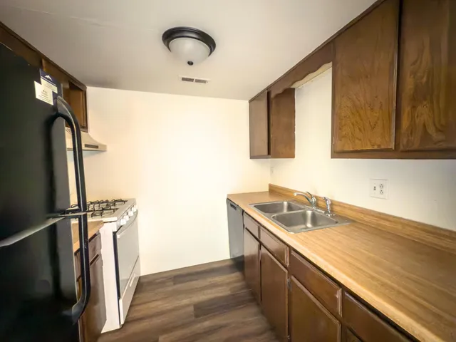 a kitchen with a sink a refrigerator and cabinets