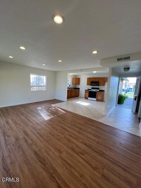 2230 Lassen Street Oxnard, CA 93033 - Photo 4 of 15 an empty room with wooden floor fireplace and windows