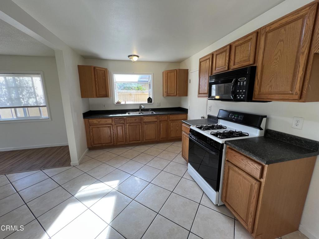 2230 Lassen Street Oxnard, CA 93033 - Photo 7 of 15 a kitchen with stainless steel appliances granite countertop a stove a sink and a microwave
