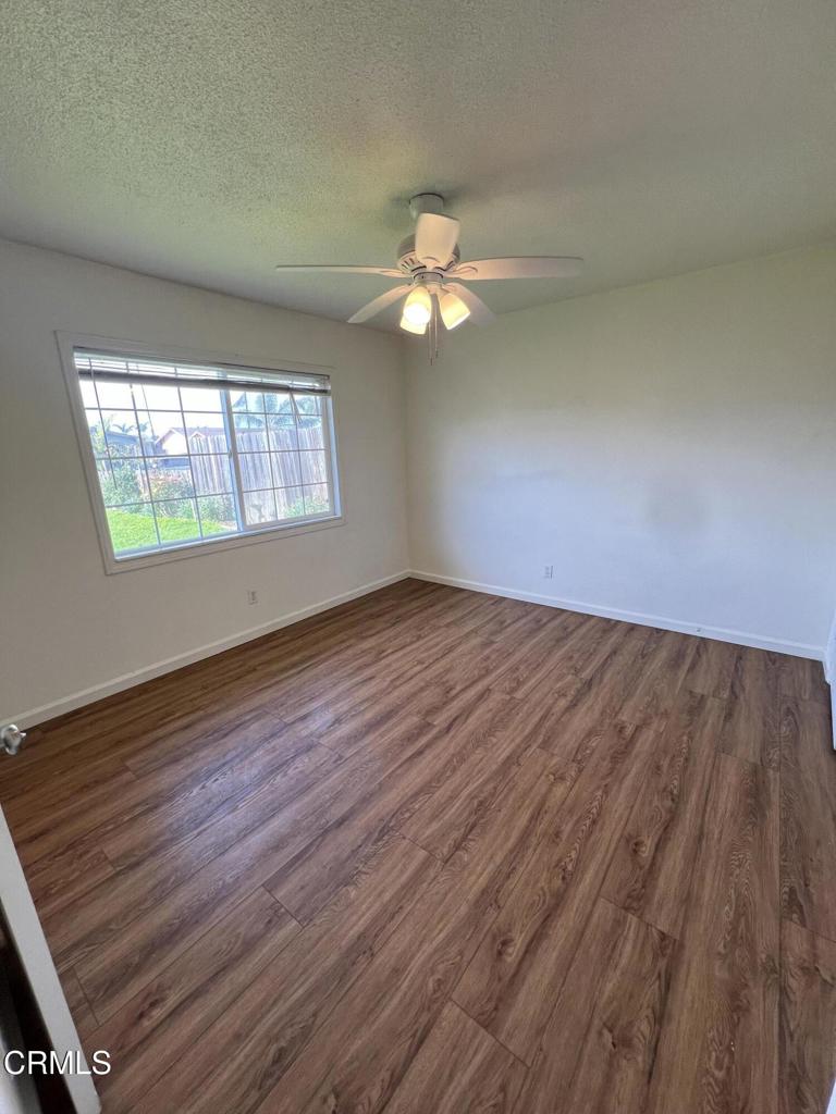 2230 Lassen Street Oxnard, CA 93033 - Photo 9 of 15 an empty room with wooden floor chandelier fan and windows