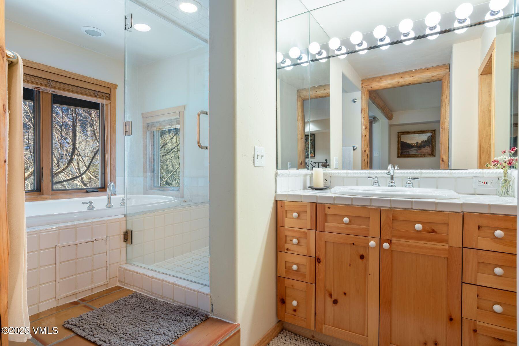 960 June Creek Road Edwards, CO 81632 - Photo 32 of 43 a bathroom with double vanity sinks a vanity a lamp and a window