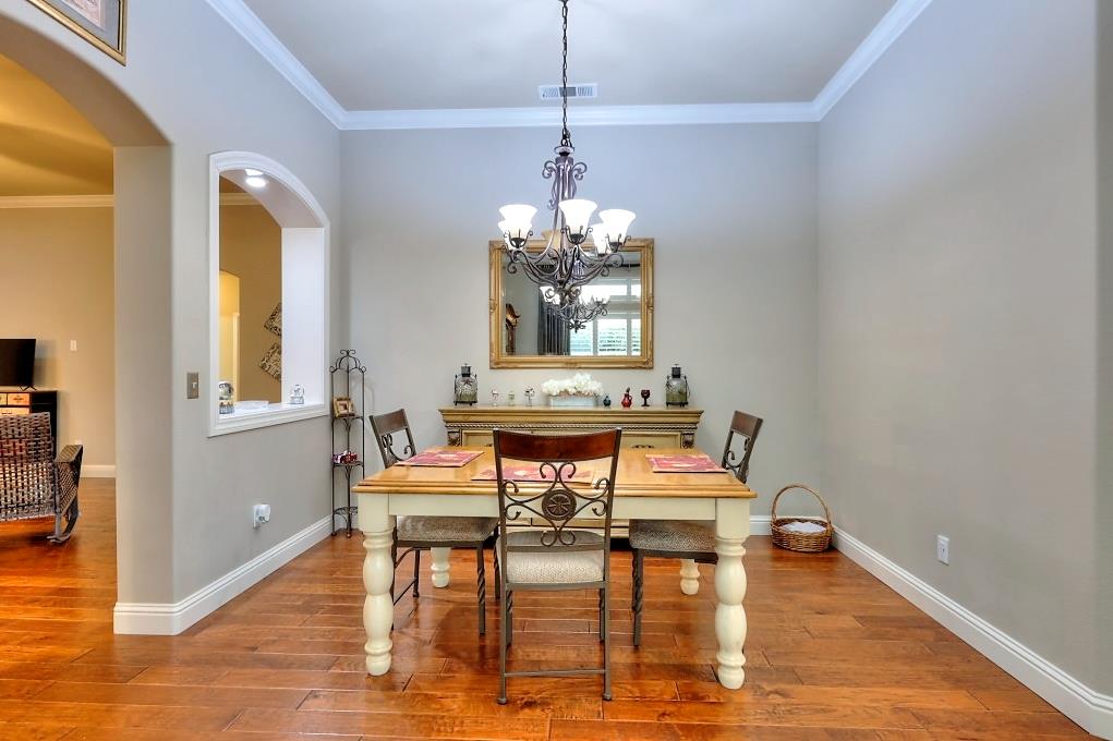 4152 Post Oak Drive Turlock, CA 95382 - Photo 20 of 71 a dining room with chandelier and wooden floor