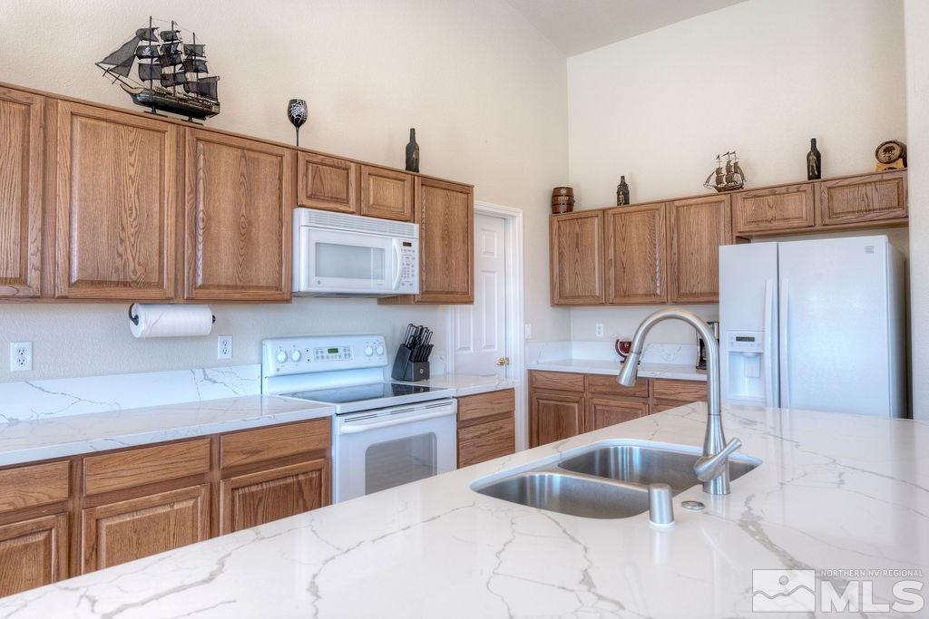 8964 Mahon Drive Reno, NV 89506 - Photo 8 of 25 a kitchen with granite countertop a sink stainless steel appliances and cabinets