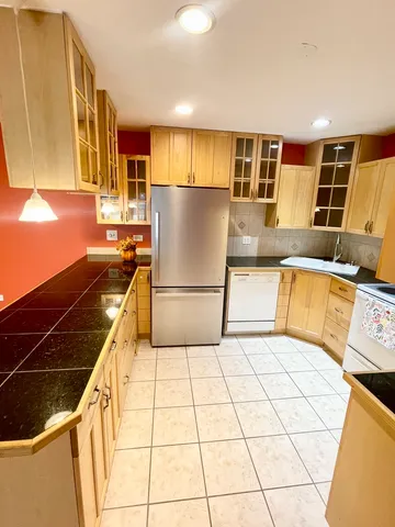 a kitchen with stainless steel appliances granite countertop a refrigerator a stove and a sink with granite countertops
