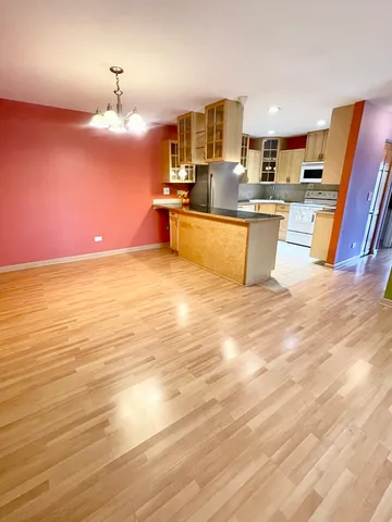 a large white kitchen with wooden floor