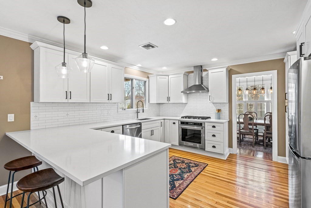20 Walnut Street Needham, MA 02492 - Photo 5 of 27 a kitchen with stainless steel appliances a stove a sink a kitchen island with a stove and white cabinets
