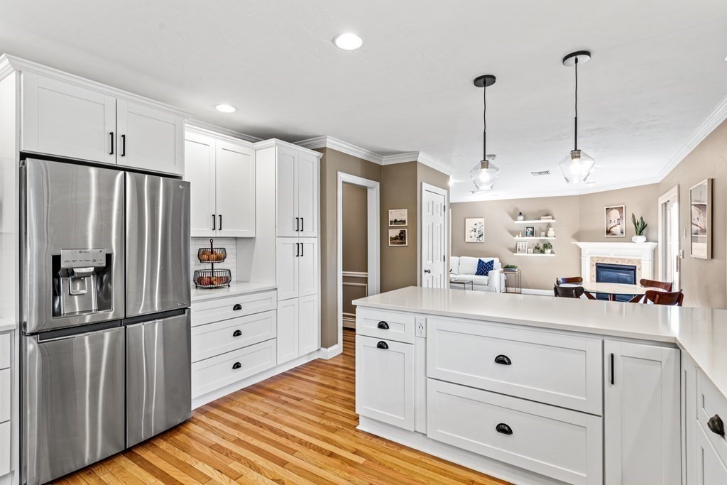 20 Walnut Street Needham, MA 02492 - Photo 7 of 27 a kitchen with stainless steel appliances kitchen island granite countertop a refrigerator a stove and a wooden floors