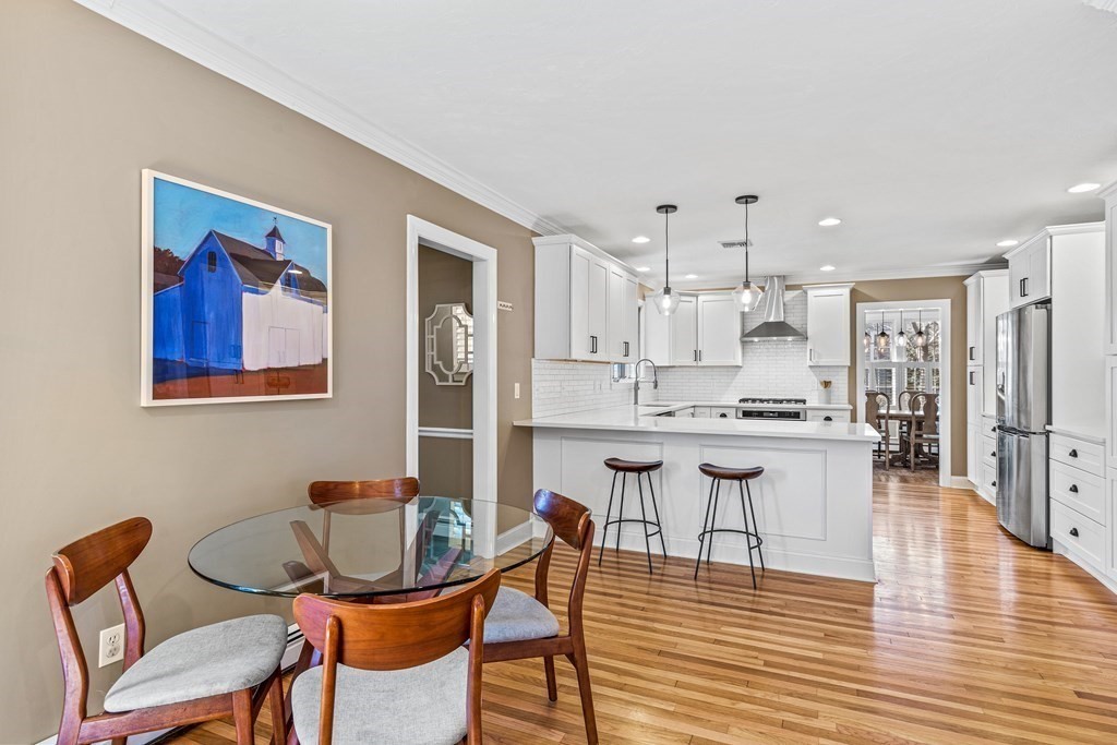20 Walnut Street Needham, MA 02492 - Photo 8 of 27 a kitchen with stainless steel appliances kitchen island granite countertop a dining table chairs and a refrigerator